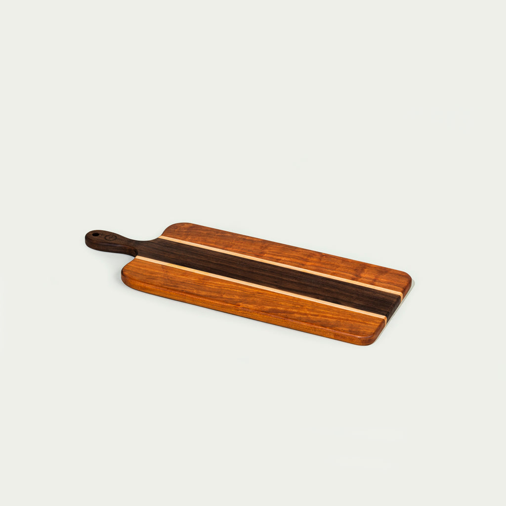 Cherry and walnut handmade charcuterie board on white background.