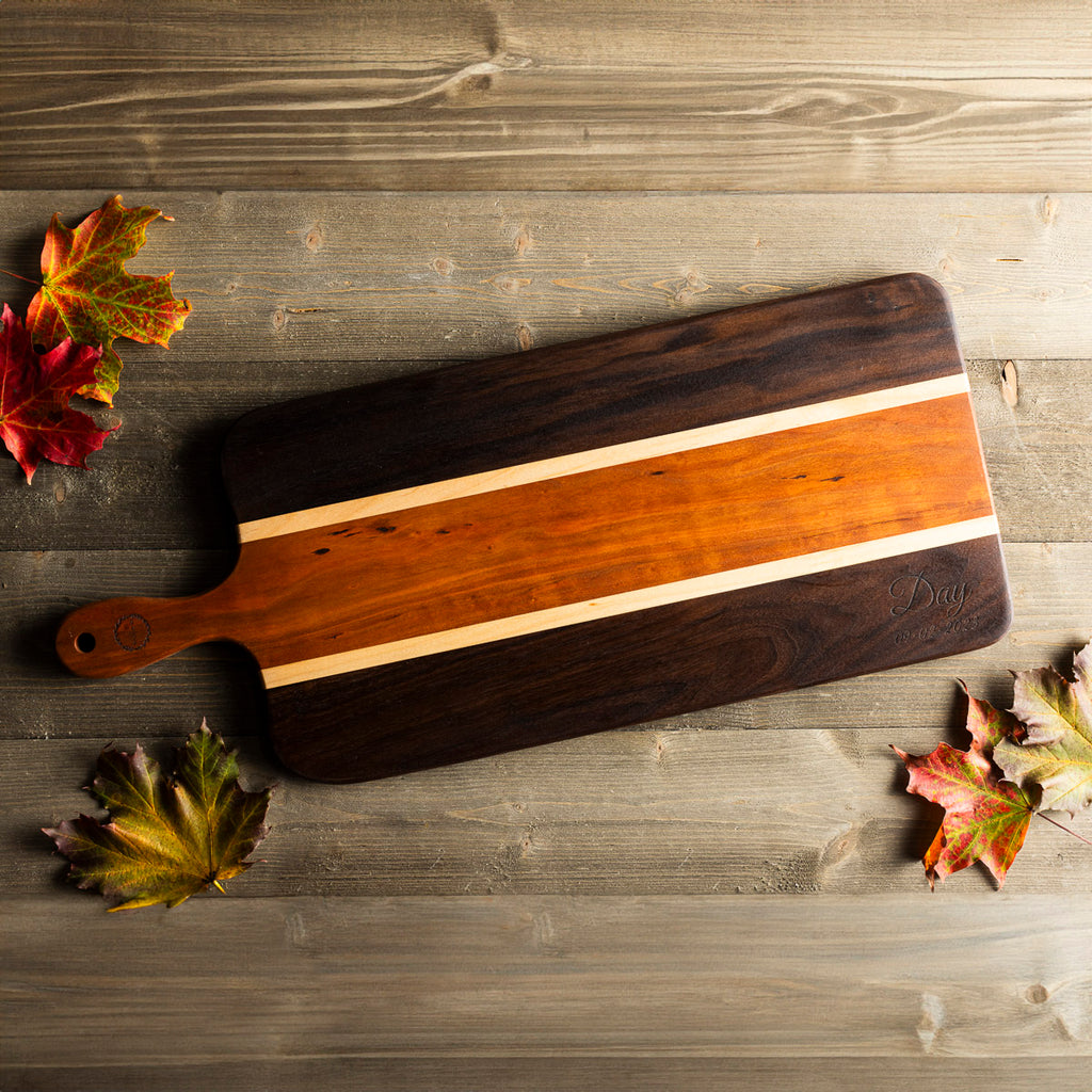 Handmade wood charcuterie board made with cherry and walnut on old barn wood with Vermont maple leaves.