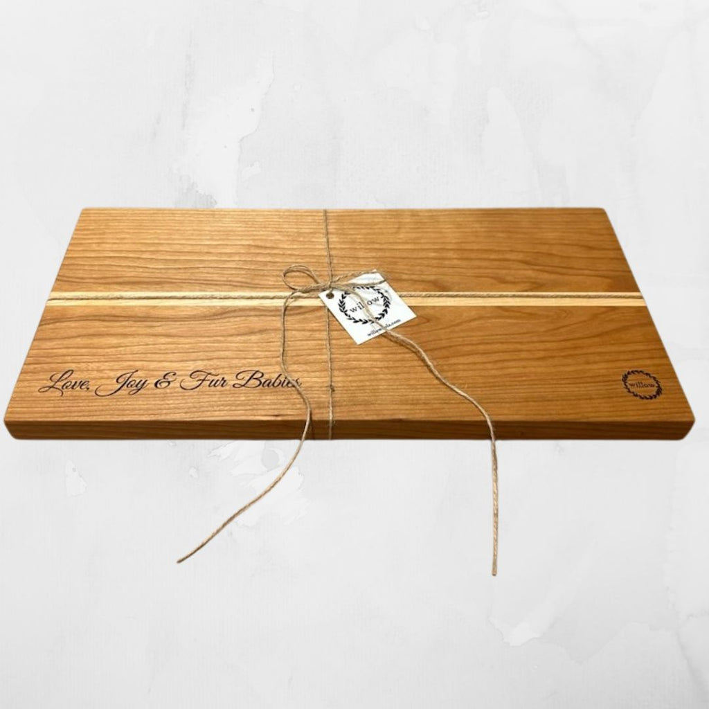 Wood cheese board wedding gift with engraved text and a tag on a white background
