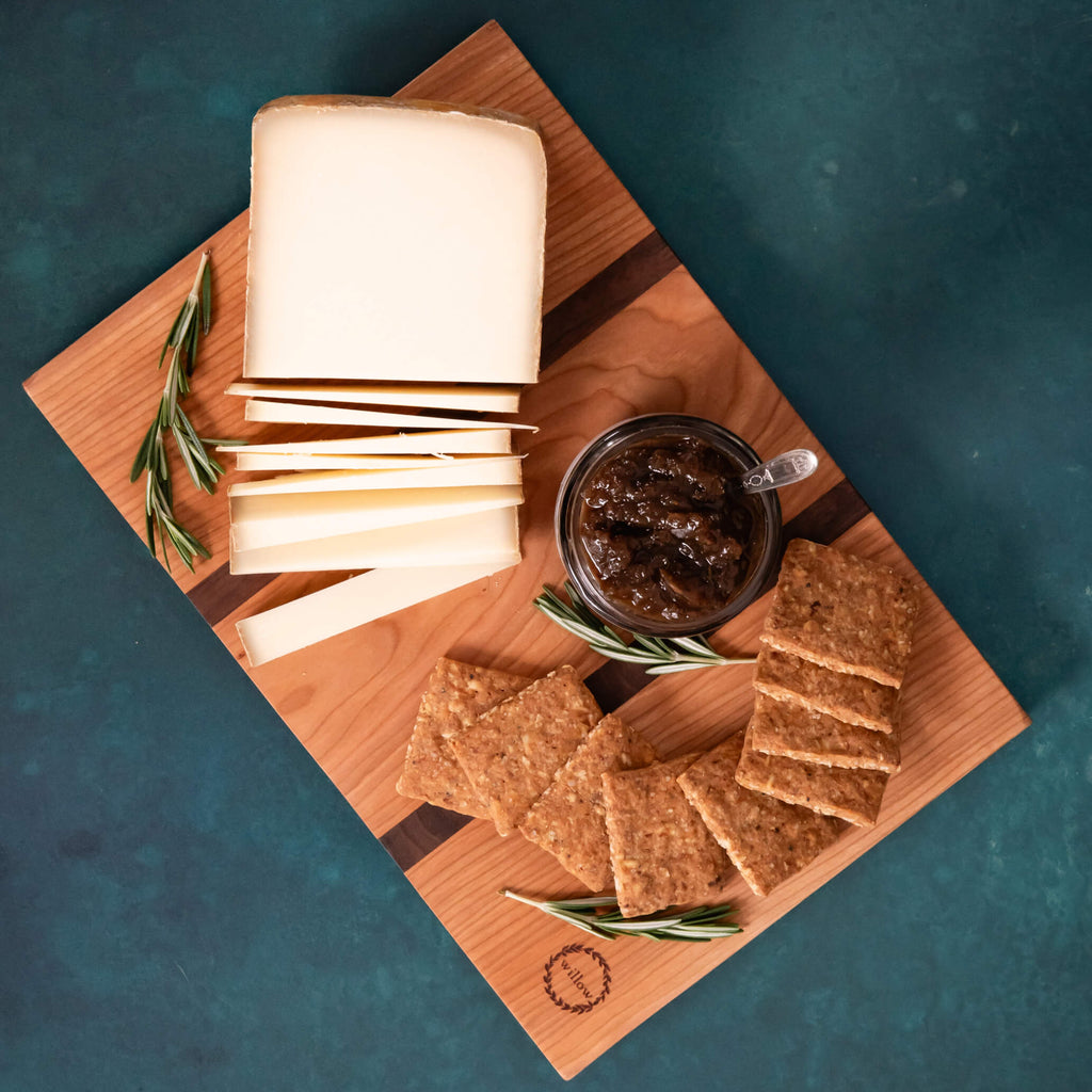 Small cheese board with cheese, crackers and jam.