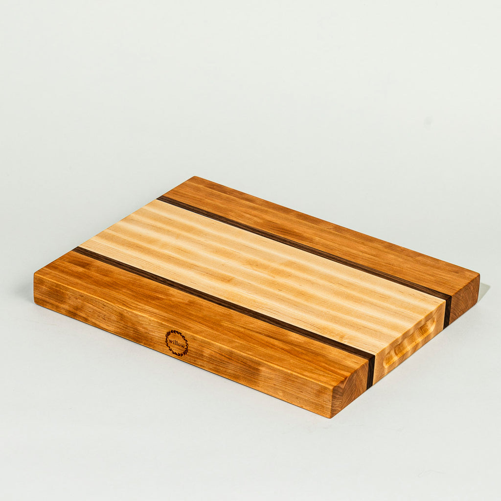 Handcrafted Willow Wood Cutting Board made of cherry and maple on clear background.