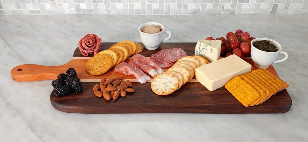 Charcuterie display including cured meats, Vermont cheese, sauces, fruit and nuts on a handmade Charcuterie Board made in Vermont. 